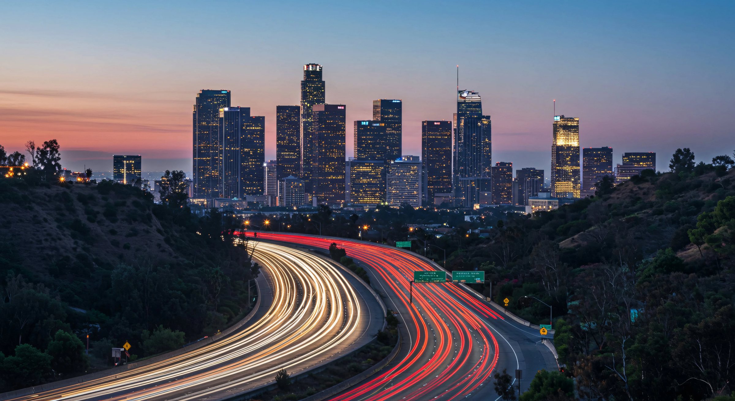Downtown Los Angeles skyline at dusk with freeway light trails